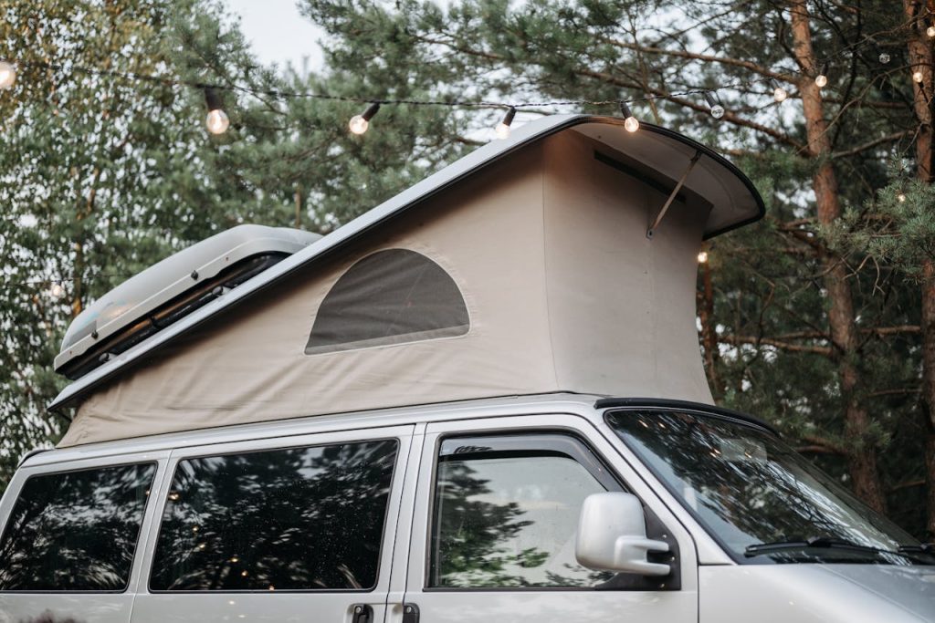 Van avec toit relevable ouvert sous les arbres